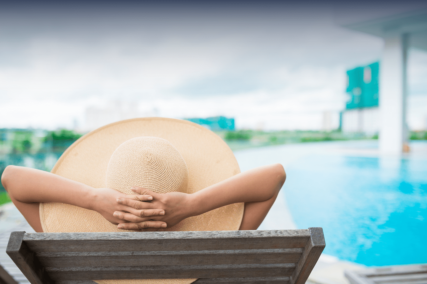 Property Management Mackay - Woman relaxing by pool with sunhat - Manage with Certainty at Mackay City Property